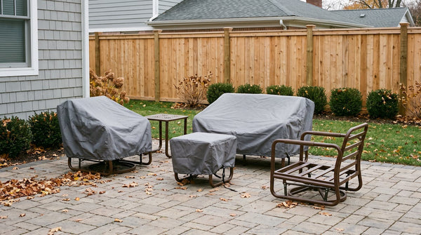 Patio set packed down for winter with fitted grey covers, one bare aluminum frame with its cushions already removed