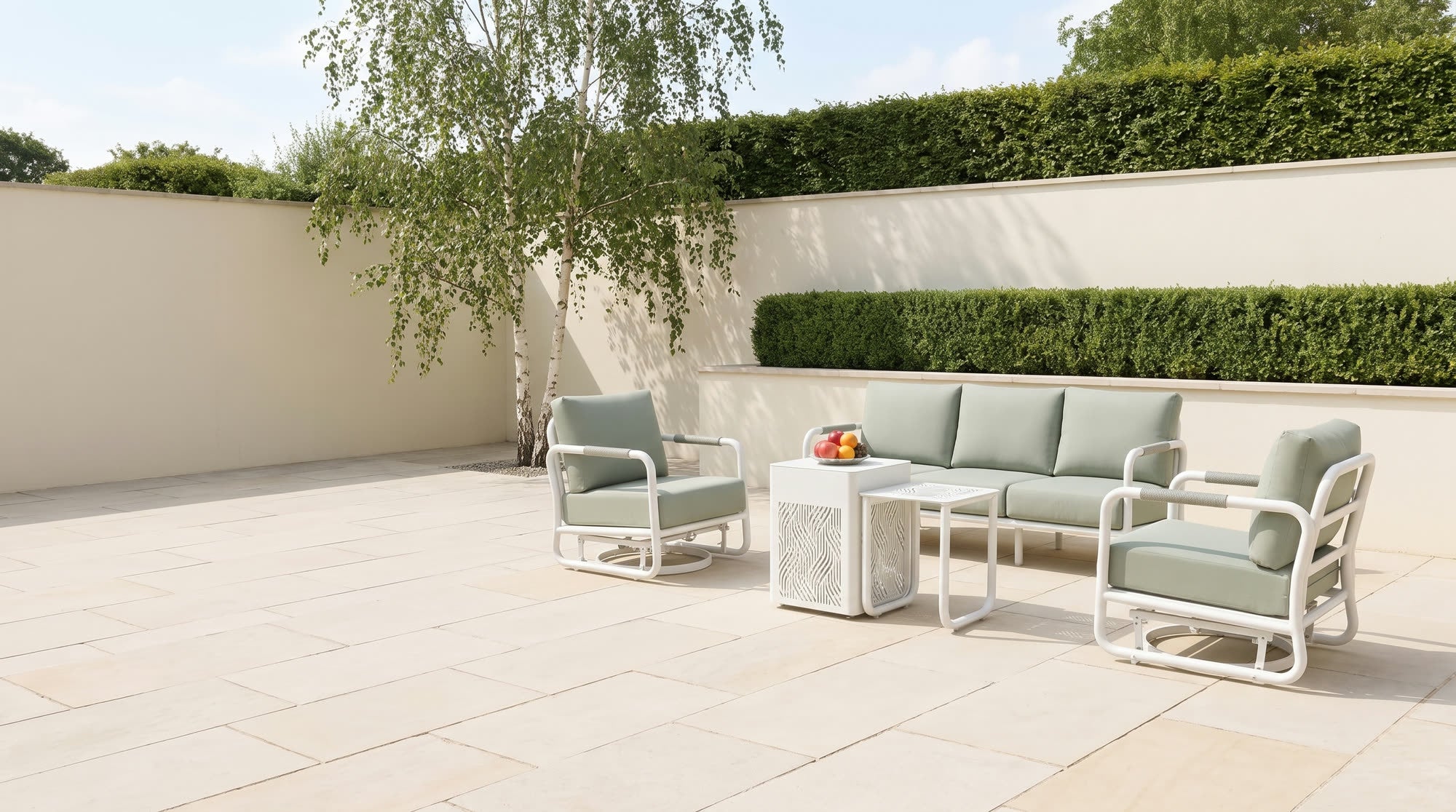 White-framed aluminum sofa set with sage cushions on a stone patio