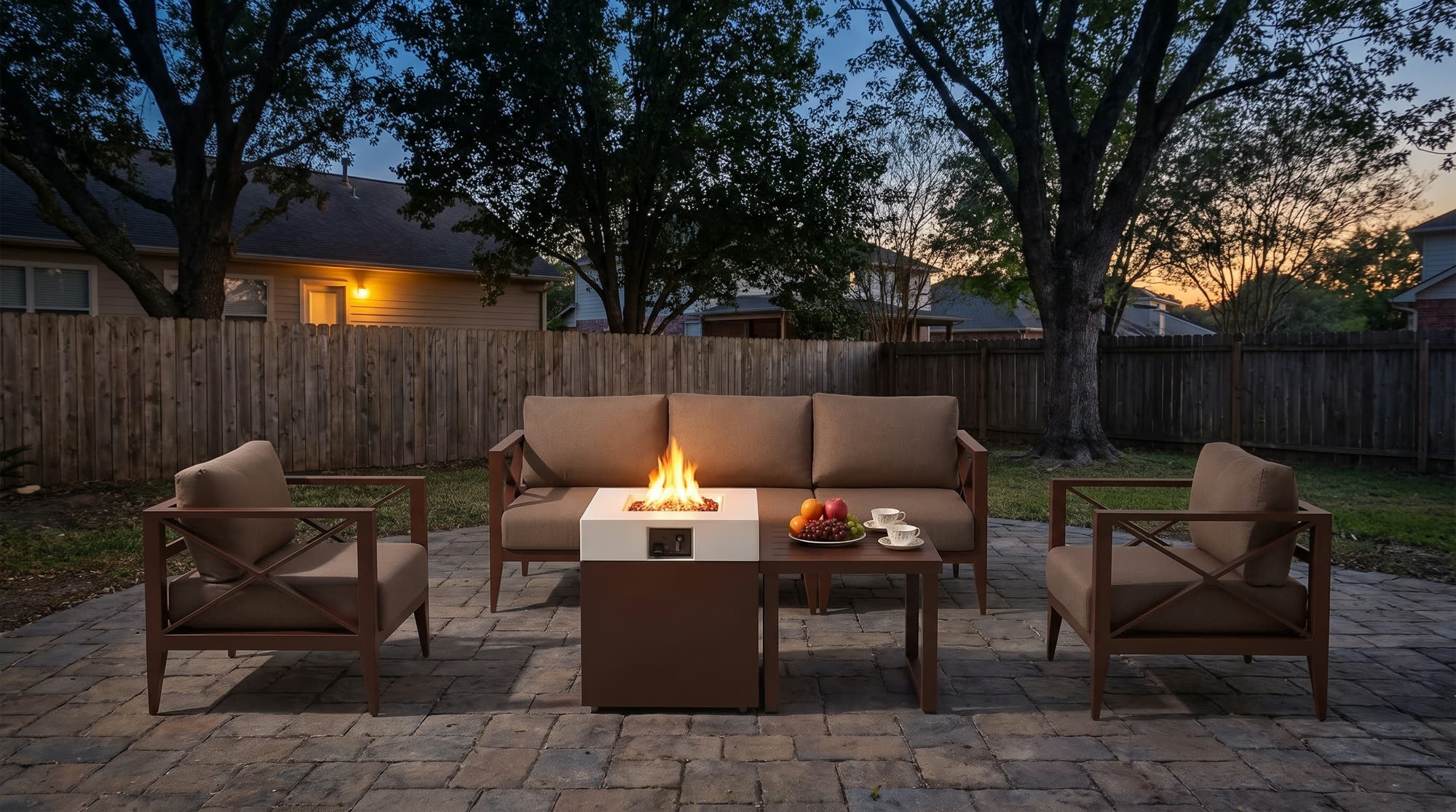 Aluminum conversation set with its fire pit table lit at dusk in a real backyard